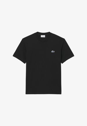 Camiseta de algodón negra con cuello redondo y mangas cortas, con un pequeño logo bordado de cocodrilo en el lado izquierdo del pecho.