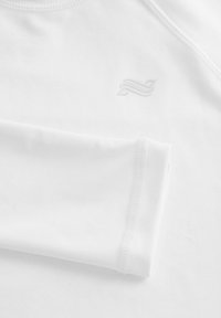 White athletic shirt featuring a round neck, long sleeves, smooth texture, and a subtle embossed logo on the chest.