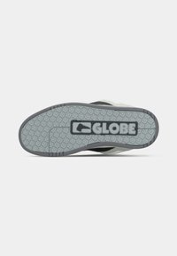Semelle de chaussure de sport grise et noire avec un motif de bande de roulement texturé et un grand logo "GLOBE" au centre.