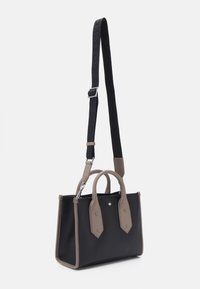 Czarna torebka z be�żowymi akcentami, o usztywnionej konstrukcji, z dwoma górnymi uchwytami i odpinanym paskiem na ramię. Zawiera srebrne logo i ozdobę na guziku.