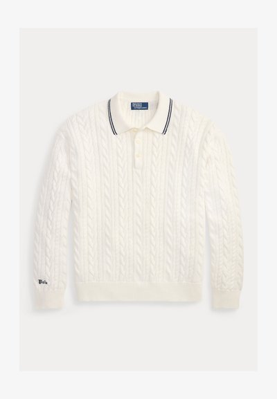 Pull polo blanc à manches longues en maille torsadée, col boutonné et détail rayé bleu marine, brodé "Polo" sur le poignet gauche.