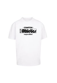 White cotton t-shirt featuring black printed text: “COMPTON” and “Athletics” with a globe graphic. Short sleeves, standard fit.
