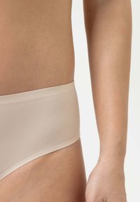 Beige stretch stof hipster onderbroek met een soepele tailleband, gekenmerkt door een zachte textuur en minimalistisch ontwerp, getoond op taillehoogte.