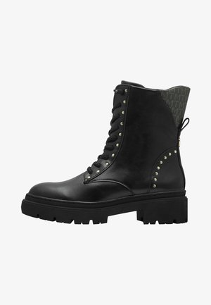 Bottine en cuir noir à lacets avec des clous décoratifs, un panneau arrière texturé, une semelle épaisse et une languette de traction. Présente un motif de semelle robuste pour une bonne adhérence.