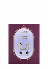 Gouden hoepel oorbellen met diepblauwe zirconia stenen, gepresenteerd tegen een paarse displaykaart met merknaam en productdetails.