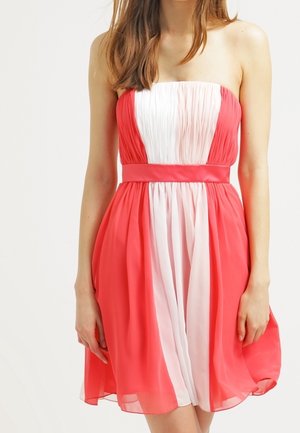 Zonder bandjes jurk met geplooide koraalrode en witte stof, een aangesloten tailleband en een uitlopende rok. Gemaakt van lichtgewicht, doorschijnend materiaal.