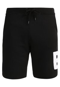 Shorts en coton noir avec une taille ajustable, des poches latérales et un motif en relief blanc représentant la lettre "B" sur la jambe.