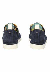 Sneakers in suede blu navy con suola bianca. Parte posteriore aperta, con dettagli gialli e blu, e una fodera geometrica a motivo verde e bianco.