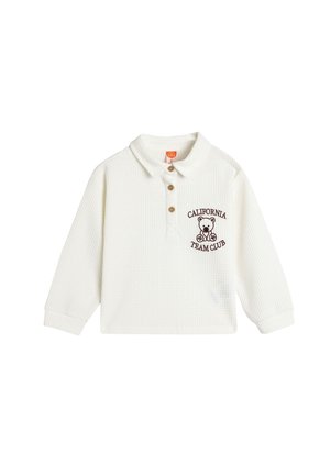 Hvid langærmet polo t-shirt med krave, tre brune knapper og et bjørnegrafik med teksten "CALIFORNIA TEAM CLUB". Tekstureret stof.