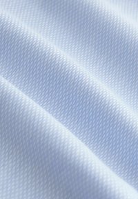 Hellblauer, strukturierter Stoff mit diagonaler Rippstruktur, der leicht erhöhte Linien aufweist und eine sanfte, glatte Erscheinung hat.