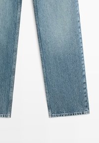 Jasnoniebieskie jeansy o prostych nogawkach z delikatnym blaknięciem i wykończonymi brzegami na białym tle.