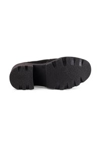 Black rubber shoe sole with a textured surface, featuring deep treads and a rounded heel. Durable design for traction and stability.