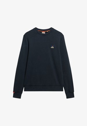 Sudadera de color azul marino hecha de algodón, con un cuello redondo, puños acanalados y un pequeño parche con logo en el pecho. Textura suave.