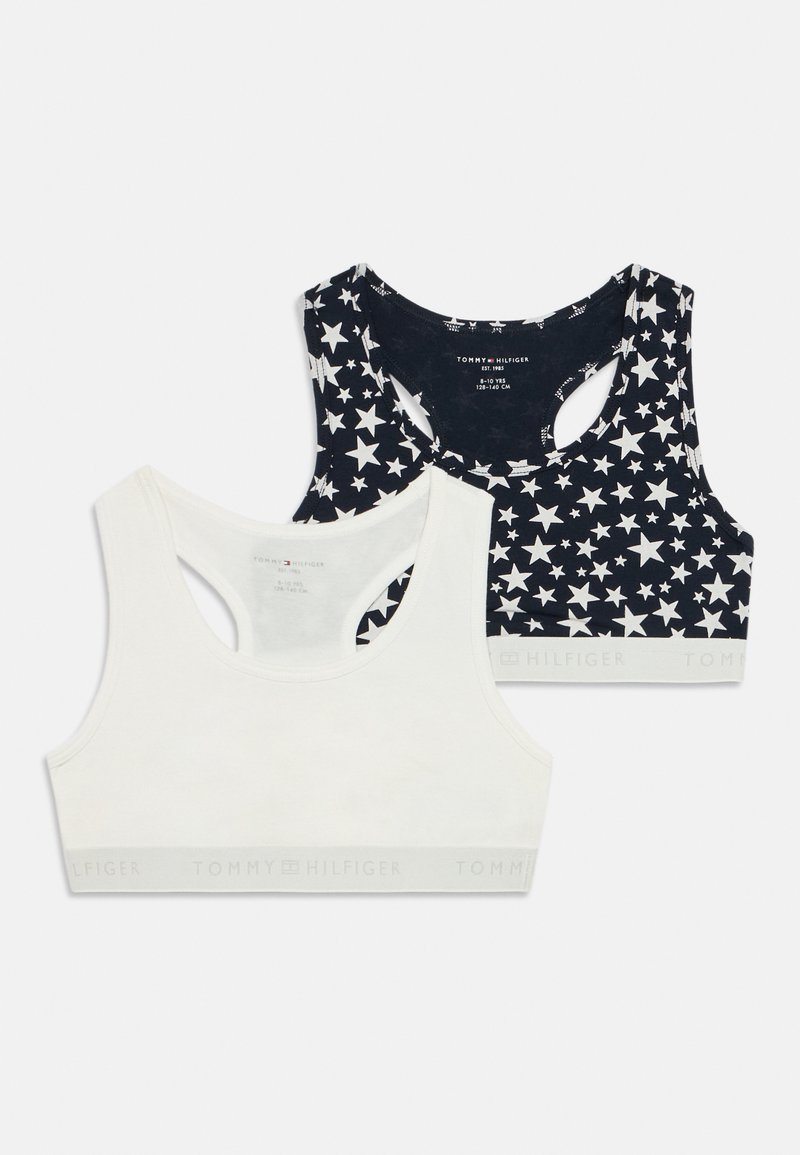 To bomulls-bra: en hvit med glatt tekstur; en marineblå med hvitt stjernemønster, racerback-design og merket elastisk band.