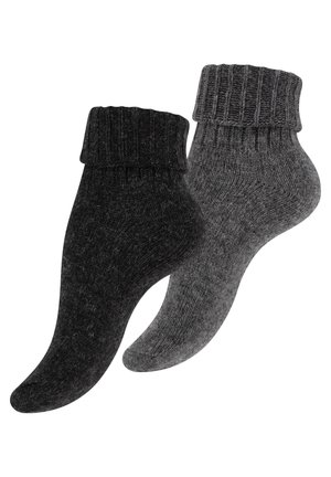 Deux paires de chaussettes ; une noire et une gris foncé. Texture tricotée avec un design de bord-côte. Les deux sont de longueur cheville avec une apparence légèrement duveteuse.