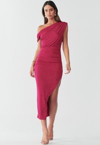 Fitted one-shoulder dress in deep magenta. Ruched fabric with a side slit and asymmetric hem. Smooth texture, below knee length, thigh-high slit.
