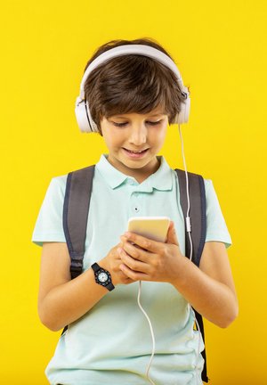 Een jonge persoon in een lichtgroen poloshirt en een grijze rugzak houdt een smartphone vast. Witte oordopjes zijn gedragen over kort bruin haar.