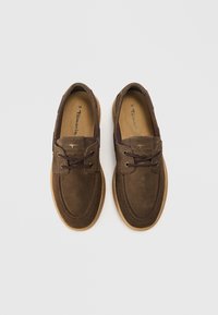 Καφέ μουτόν casual παπούτσια με στρογγυλές μύτες, κορδόνια και ταμπά λαστιχένιες σόλες. Διαθέτουν ραφές και χρυσές λεπτομέρειες. Μέγεθος 38.