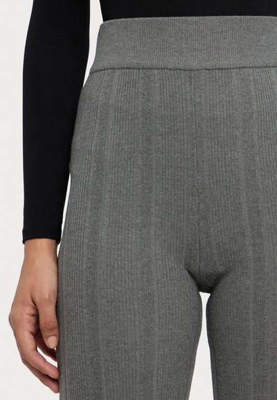 Pantaloni gri cu nervuri, având un brâu elastic lat și o siluetă ajustată, evidențiind textura verticală și materialul elastic.