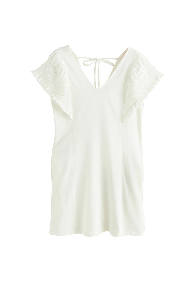 Haut blanc à manches courtes avec un décolleté en V et un détail à nouer dans le dos. Présente des manches volantées et une texture de tissu douce.