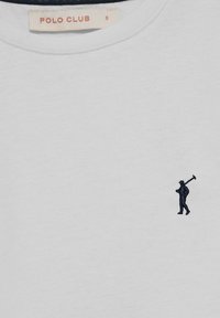 Ljust grå bomulls t-shirt med rund halsringning. Har en liten mörkblå broderad figur som bär en golfklubba på vänster sida.