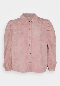 Camisa de pana rosa con cuello de camisa, mangas abullonadas y cierre de botones. Presenta una textura de rayas verticales y puños elásticos.