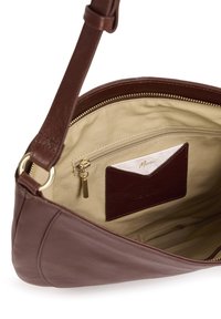 Braune Leder-Umhängetasche mit beigem Innenfutter aus Stoff, goldfarbenem Reißverschluss und einem inneren Kartenfach, das eine mit "Merci" beschriftete Karte enthält.