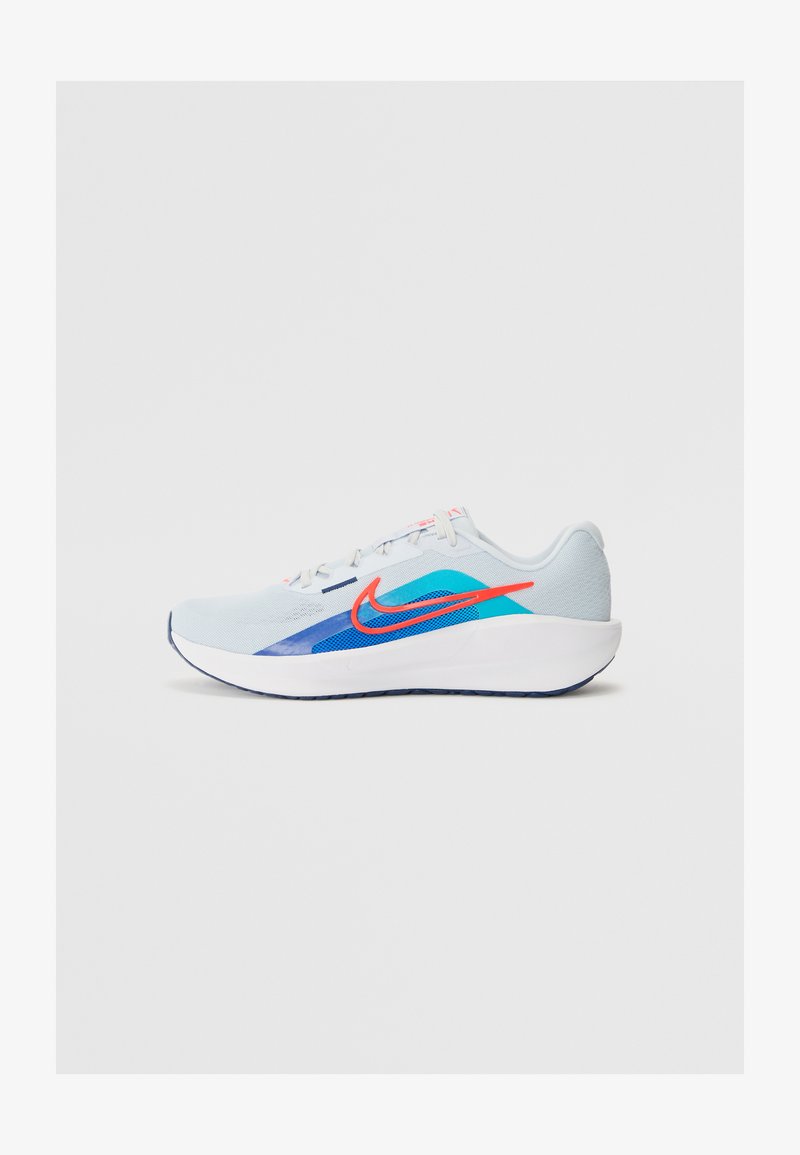 Svijetloplave atletske tenisice s mrežastim gornjim dijelom, koje imaju plave i zelene naglaske, crveni Nike znak i bijelu đon. Bočni pogled.