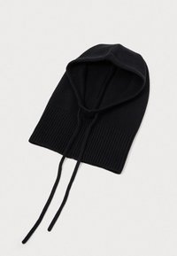 Černá pletená kukla s ribbovanou texturou, která má přiléhavou kapuci a nastavitelné šňůrky pro bezpečné nošení.