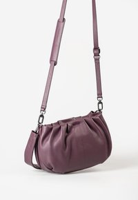 Lila Leder-Schultertasche mit gerafftem Design, ausgestattet mit einem abnehmbaren Tragegurt und metallischen Beschlägen. Glatte Textur mit strukturierter Form.