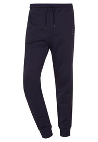 Mörkblå joggerbyxor i mjukt material, med dragsko i midjan, avsmalnande ben och ribbade mudd. Litet logodetalj på sidan.