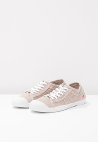 Sneakers in tela beige con punta in gomma bianca, design con lacci e piccolo dettaglio ricamato a forma di ciliegia sul lato. Suola piatta con grip testurizzato.
