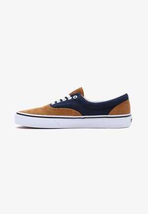 Blue and brown corduroy sneaker with white laces, rubber sole, and contrasting stitching. Features a prominent toe cap and textured fabric.