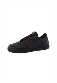 Sneaker noir à lacets avec tige synthétique, présentant un corps texturé, un subtil accent rouge, et un logo embossé sur le côté. Semelle en caoutchouc.