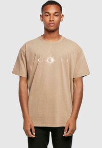 Beige bomulds T-shirt med et himmelsk design af sol- og månefaser, afslappet pasform og korte ærmer. Enkel rund halsstil.