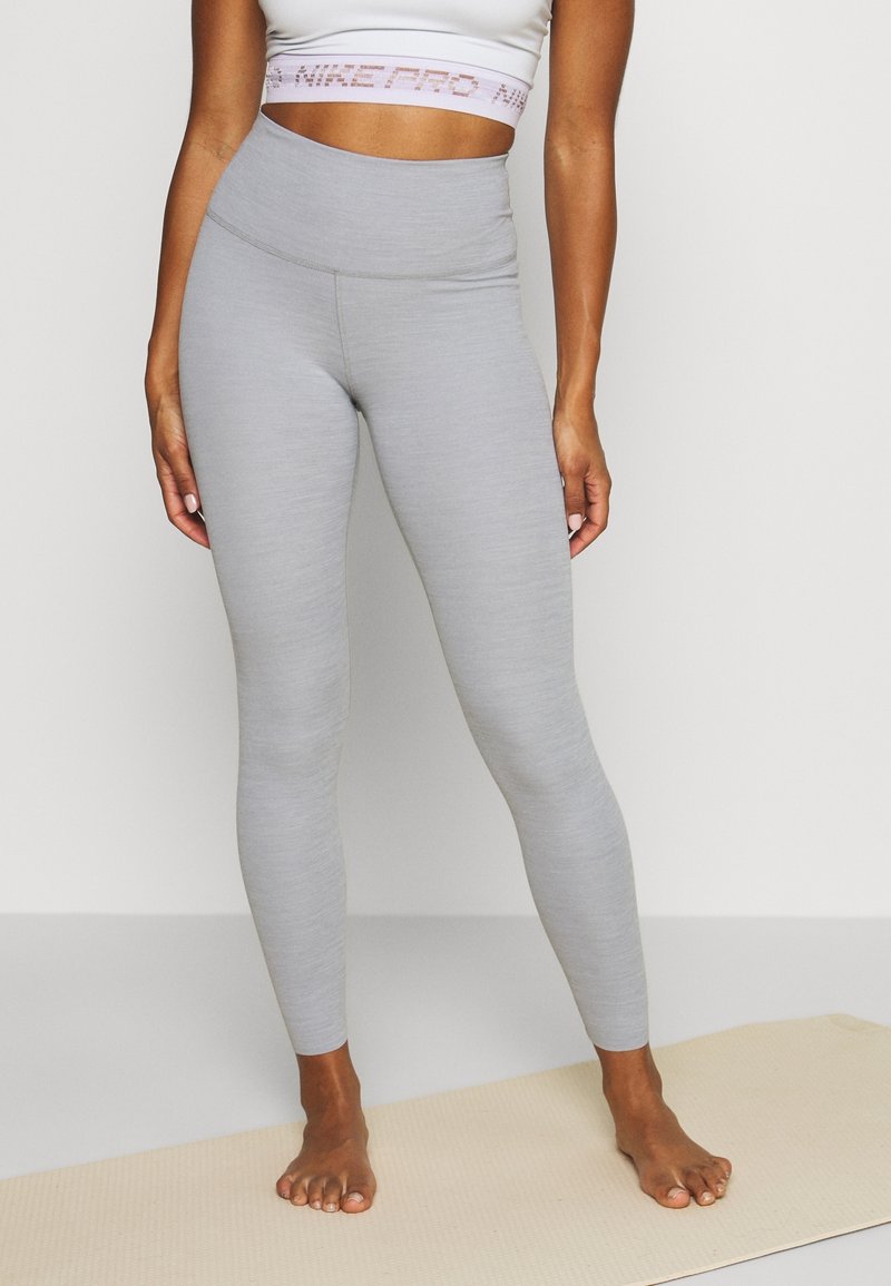 Leggings grigi in tessuto elasticizzato, con vita alta e dettagli delle cuciture minimi, caratterizzati da una texture liscia per il massimo comfort.
