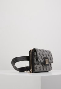 Bolso bandolera gris y negro con un acabado texturizado, cierre con cremallera y placa de logo. Cuenta con una correa ajustable y desmontable.
