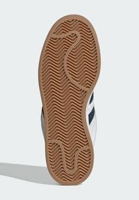 Talpa de pantof cu un design texturat și ondulat, din cauciuc bej, cu o formă rotundă; partea superioară contrasta cu piele albă și țesătură marineză.