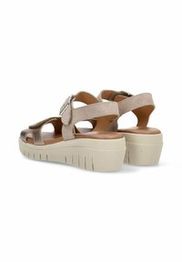 Sandalias de plataforma beige con parte superior de cuero suave, correa ajustable y diseño de punta abierta. Suela texturizada que proporciona tracción.