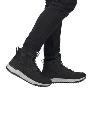 Zapatos de senderismo negros de corte medio con suela gris, que presentan un upper texturizado, cierre de cordones y cremallera lateral. Diseño duradero y versátil.