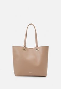 Beige tote bag with two tote handles, made of smooth material. Square gold hardware accents on the handles. Logo printed at the bottom.