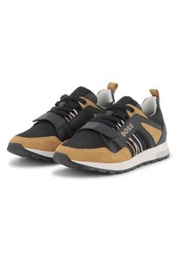 Pantofi sport negri și căprui, din suede și material textil, cu talpă din cauciuc, sistem de închidere cu șireturi și o curea cu brand pe față.