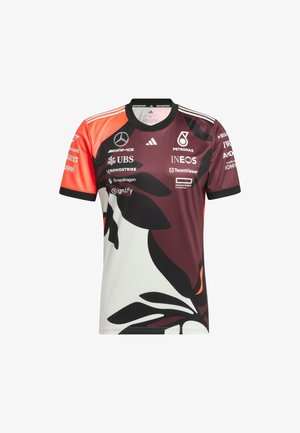 Trkačka majica u crnoj, bijeloj i crvenoj boji, s velikim cvjetnim grafikonima, rukavima u različitim bojama i brojnim logotipima sponzora.