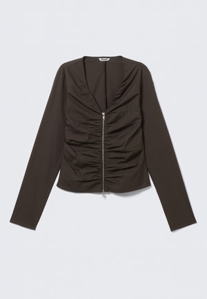 Brun bluse med lange ermer, dyp V-hals, front med rynking og en sentral glidelås ned midten. Laget av glatt, figurnært stoff.