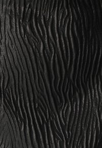 Tessuto nero con un motivo testurizzato caratterizzato da onde verticali e una leggera lucentezza, che enfatizza profondità e dimensione con una finitura liscia.