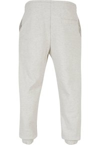 Ljusgrå sweatpants gjorda av mjukt material, med elastisk midja, sidofickor och avsmalnande muddar vid anklarna.