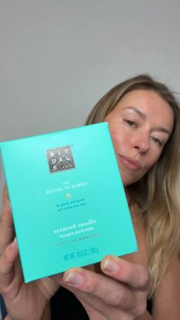 Turkis eske for duftlys "The Ritual of Karma" med sølvlogo; detaljer inkluderer "lotusblomst og hvit te" og vekt.