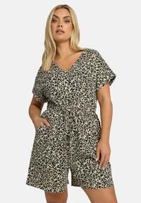 Leopardmönstrad romper med V-ringning, korta ärmar, dragsko i midjan och sidfickor. Beige bakgrund med svarta fläckar.