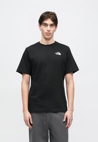 Μαύρη βαμβακερή μπλούζα με στρογγυλή λαιμόκοψη και κοντά μανίκια. Διαθέτει μικρό λευκό λογότυπο στο αριστερό πάνω μέρος του στήθους. Casual εφαρμογή, λεία υφή.