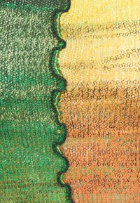 Stickad tyg med en vågig kant har gradientfärger: djupgrön som övergår till varm gul, orange och brun. Texturerad med synliga stygn.